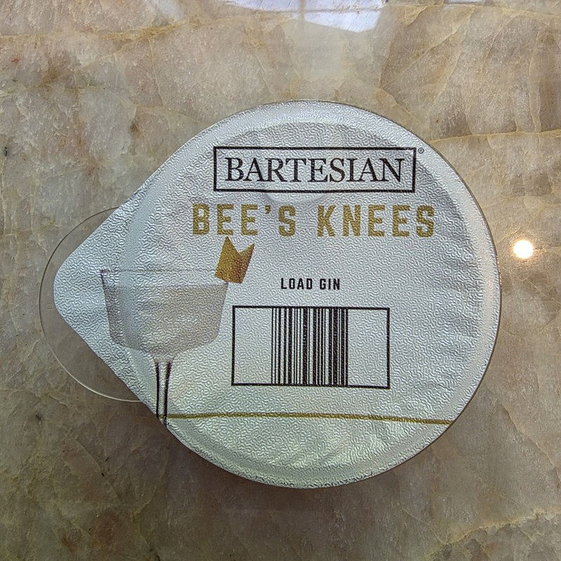 Top-down view of the Bartesian Bee's Knees capsule showing the label and Load Gin instruction