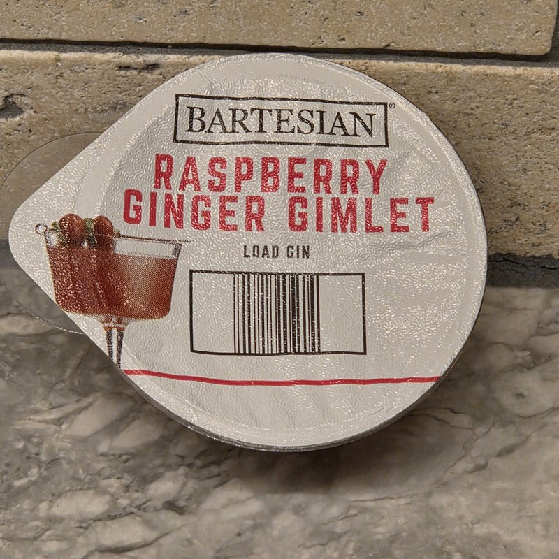 Bartesian Raspberry Ginger Gimlet cocktail pod with LOAD GIN instructions on travertine surface