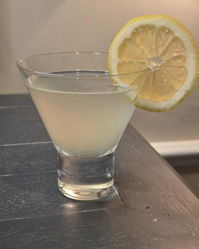 A pale Lemon Drop in a stemless glass with a lemon wheel on the rim