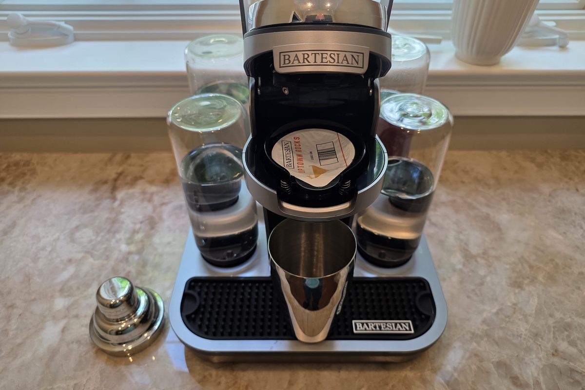 Bartesian Professional machine with the Uptown Rocks pod loaded and a stainless steel shaker tin beneath the spout